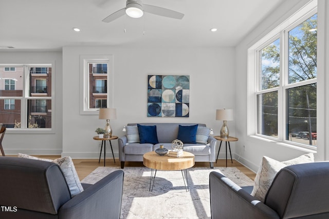 living room featuring a healthy amount of sunlight, ceiling fan, and light hardwood / wood-style floors