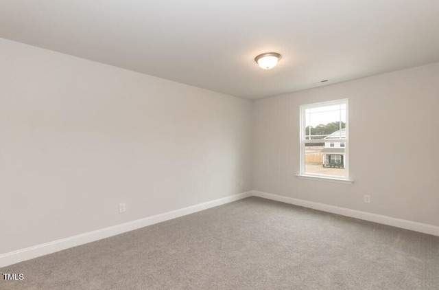 carpeted empty room with baseboards