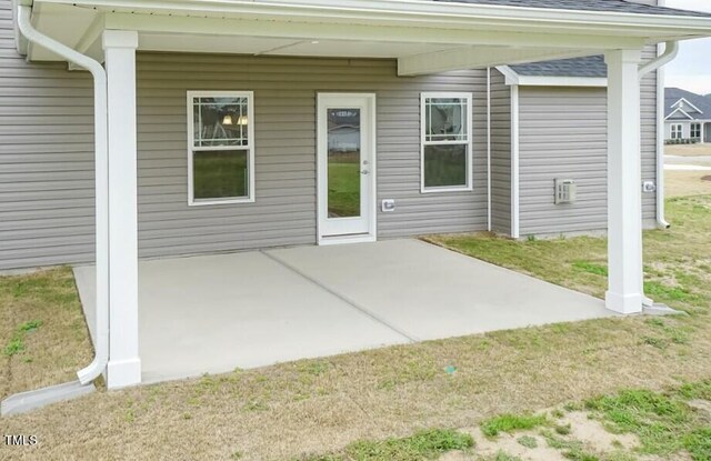 exterior space featuring a shingled roof, a patio area, and a yard