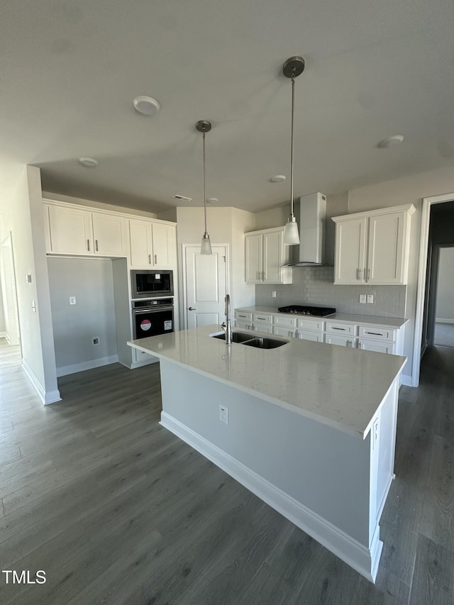 kitchen with stainless steel oven, white cabinetry, a sink, and decorative light fixtures