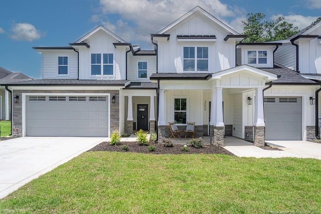 view of front facade with stone siding, a front lawn, board and batten siding, driveway, and covered porch