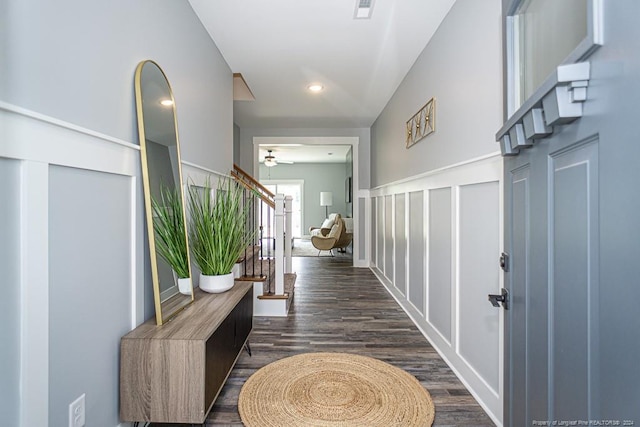 foyer entrance with dark wood finished floors, visible vents, stairway, and a ceiling fan