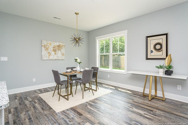 dining area with wood finished floors, baseboards, and visible vents