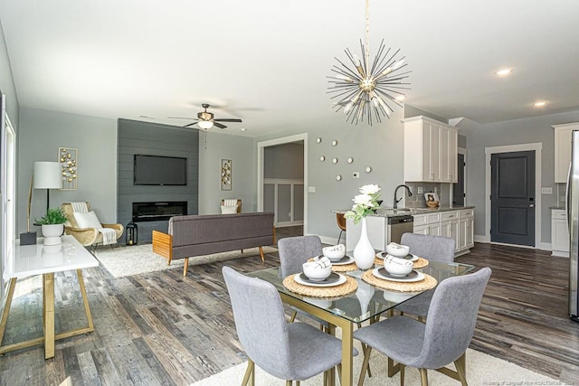 dining room with a large fireplace, baseboards, ceiling fan with notable chandelier, recessed lighting, and dark wood-style flooring