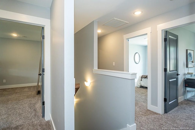 corridor with carpet floors, baseboards, recessed lighting, and visible vents