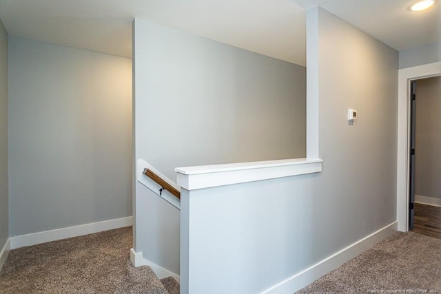 hall with baseboards, an upstairs landing, and carpet