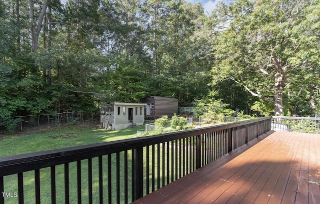 deck featuring a yard, a fenced backyard, an outdoor structure, and a shed