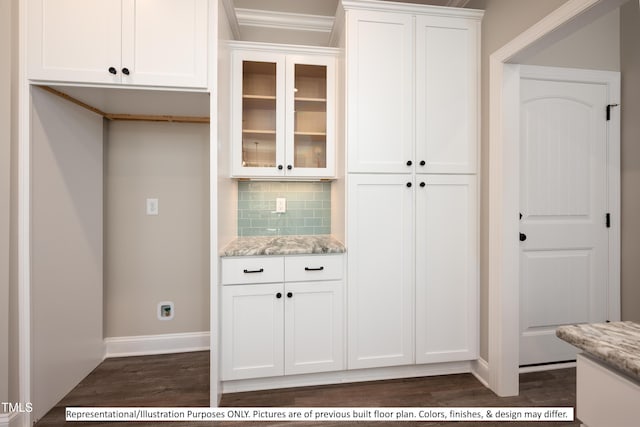 bar with dark wood-type flooring, light stone countertops, decorative backsplash, and white cabinetry