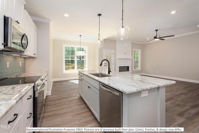 kitchen with a center island with sink, appliances with stainless steel finishes, sink, and white cabinetry