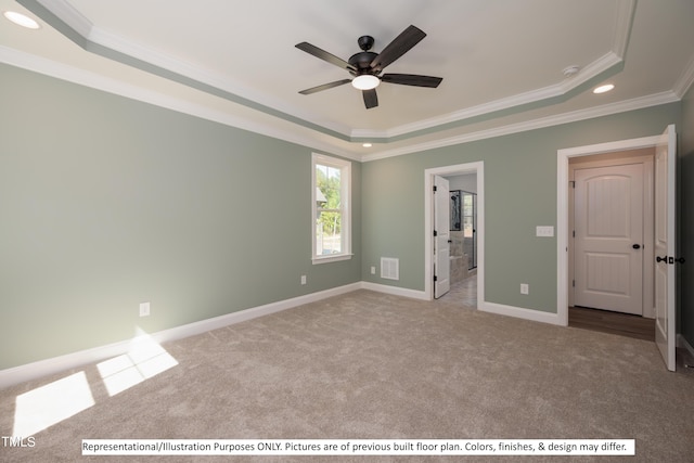 unfurnished bedroom featuring ceiling fan, a raised ceiling, ornamental molding, ensuite bathroom, and light colored carpet