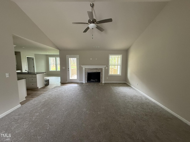 unfurnished living room featuring a premium fireplace, carpet, high vaulted ceiling, and ceiling fan