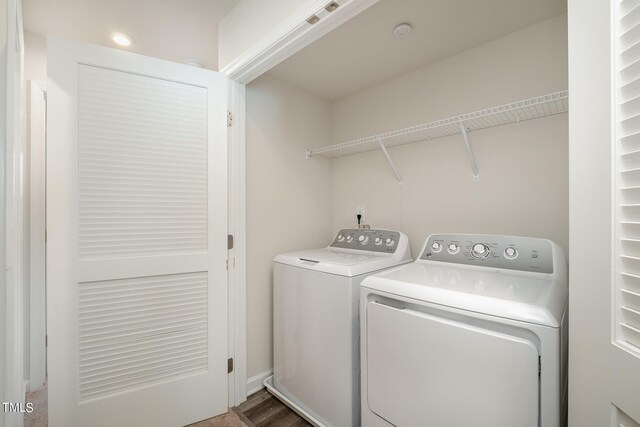 laundry area with separate washer and dryer and wood-type flooring