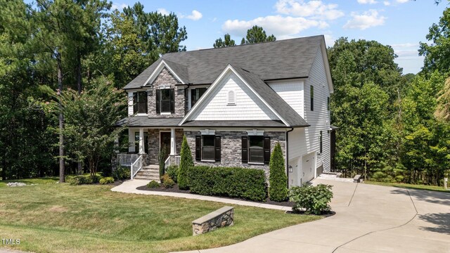 view of front of house with covered porch, a front yard, and a garage