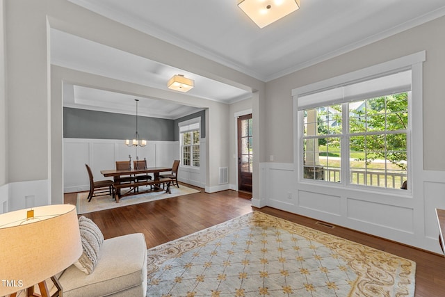 interior space with plenty of natural light, ornamental molding, and wood-type flooring