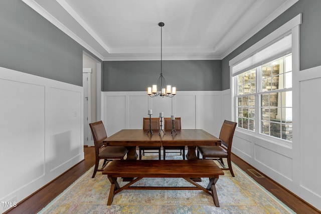 dining room with crown molding, a notable chandelier, and wood-type flooring