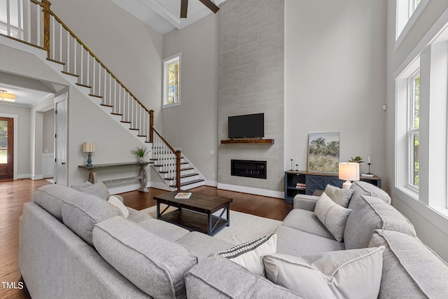 living room featuring a high ceiling, hardwood / wood-style floors, and a fireplace