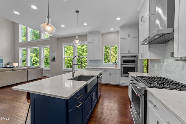 kitchen featuring dark hardwood / wood-style floors, wall chimney exhaust hood, stainless steel appliances, sink, and white cabinetry