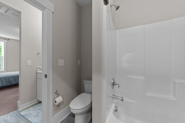 bathroom featuring toilet, hardwood / wood-style flooring, and shower / washtub combination