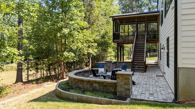 exterior space with an outdoor fire pit, a patio area, and a sunroom