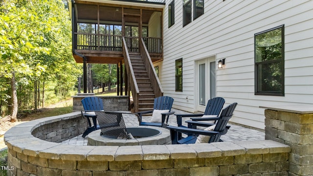 view of patio / terrace with a fire pit and a wooden deck