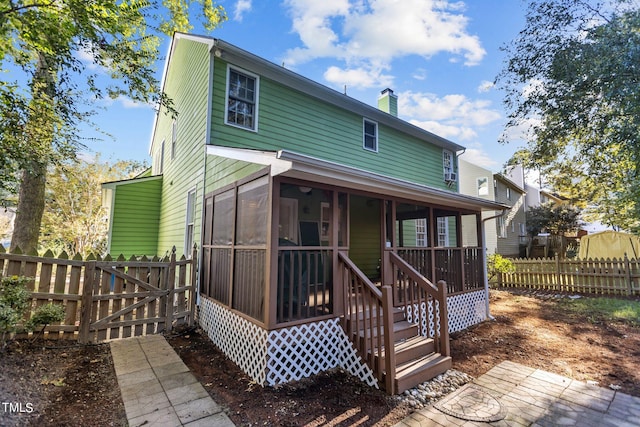 back of property with a sunroom