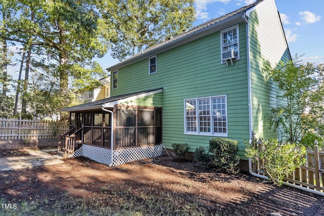 rear view of property featuring a sunroom