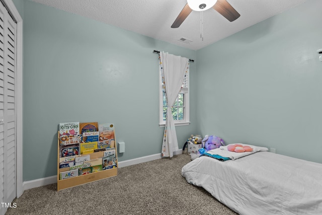 bedroom featuring carpet flooring, a textured ceiling, and ceiling fan