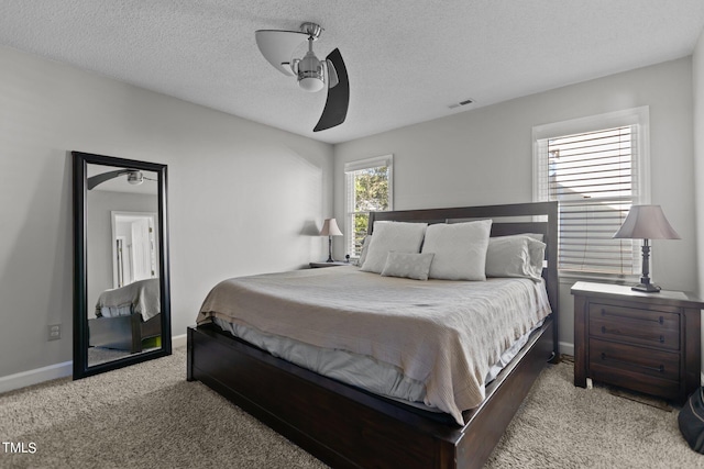 bedroom featuring light carpet, ceiling fan, and a textured ceiling