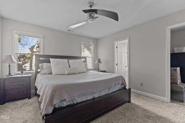 bedroom featuring a textured ceiling, light colored carpet, multiple windows, and ceiling fan