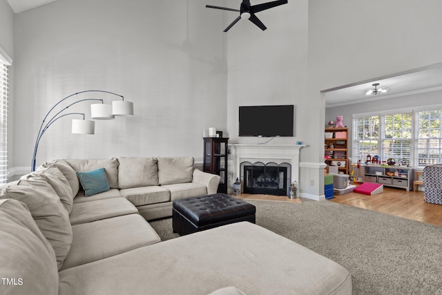 living room with ornamental molding, hardwood / wood-style flooring, high vaulted ceiling, and ceiling fan