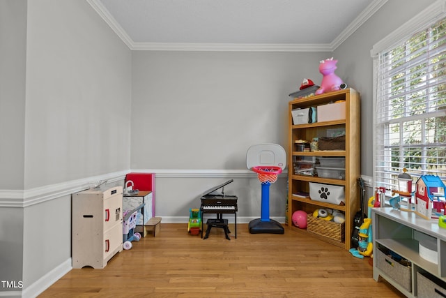 game room with ornamental molding and light hardwood / wood-style floors