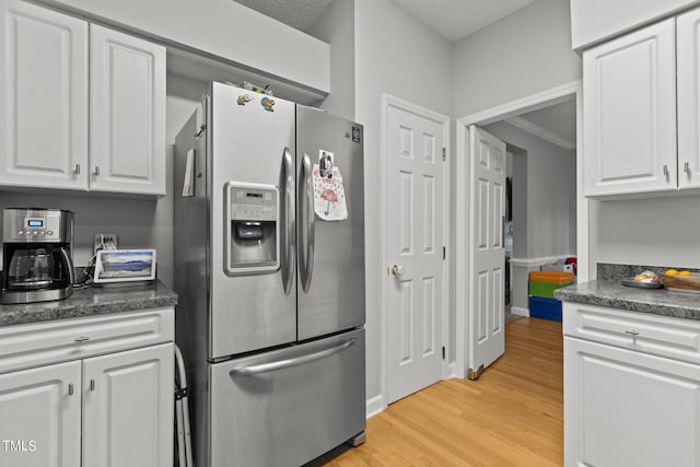 kitchen with ornamental molding, stainless steel fridge with ice dispenser, light hardwood / wood-style flooring, and white cabinetry