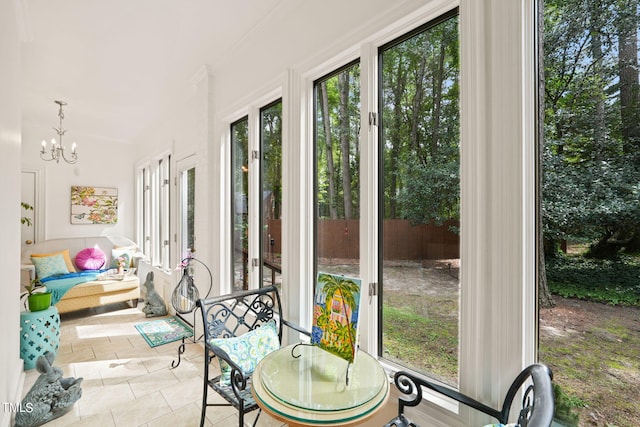 sunroom / solarium featuring a chandelier