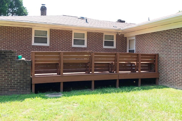 back of house featuring a wooden deck and a yard