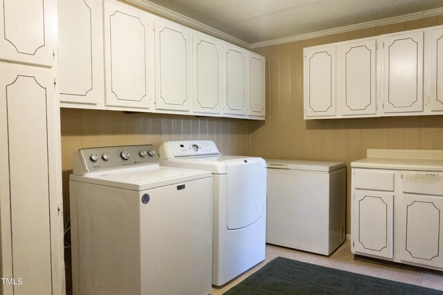 washroom featuring cabinets, washer and clothes dryer, ornamental molding, and light tile patterned flooring