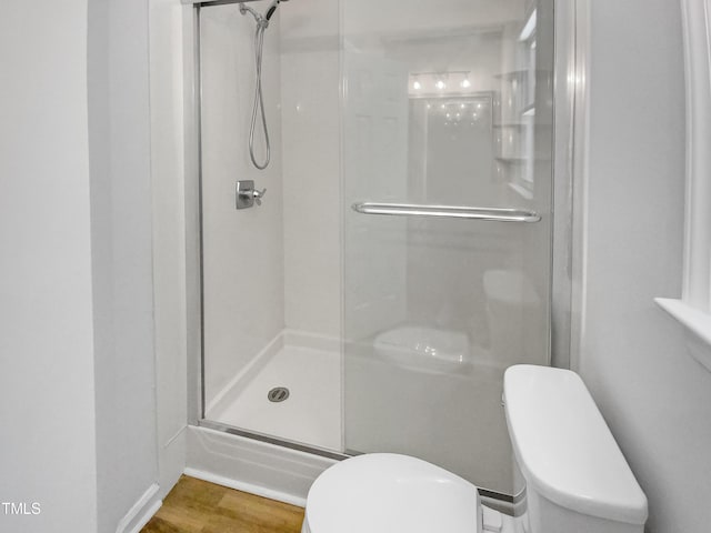 bathroom featuring wood-type flooring, an enclosed shower, and toilet