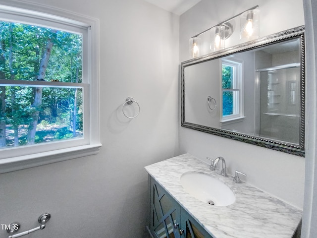 bathroom featuring plenty of natural light, an enclosed shower, and vanity