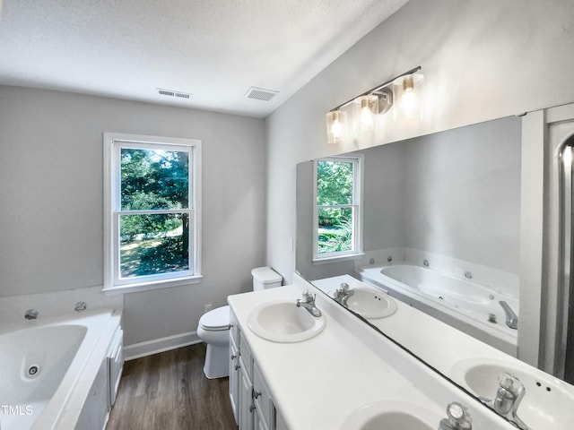 bathroom featuring a bathtub, hardwood / wood-style flooring, toilet, and vanity