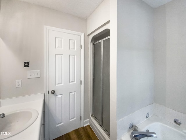 bathroom featuring hardwood / wood-style flooring, a textured ceiling, separate shower and tub, and vanity