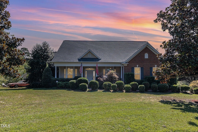 view of front of property with a porch and a yard