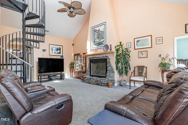 living room with carpet flooring, high vaulted ceiling, ceiling fan, and a stone fireplace