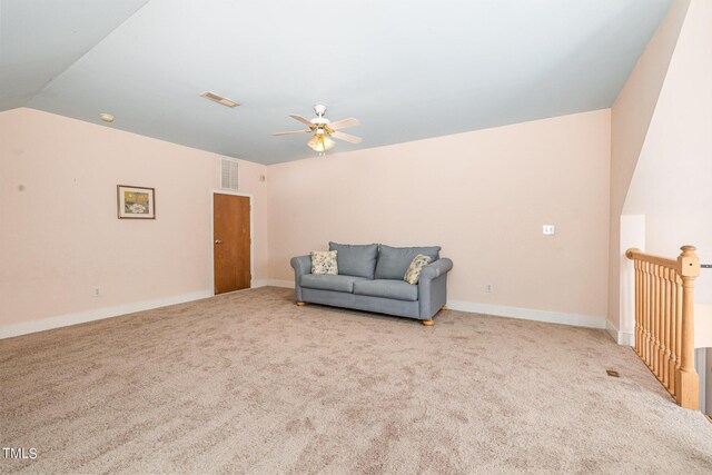 living area with ceiling fan, light colored carpet, and vaulted ceiling