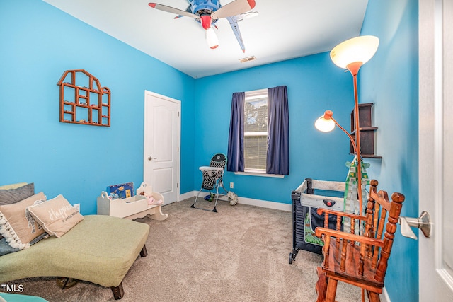 sitting room featuring ceiling fan and carpet