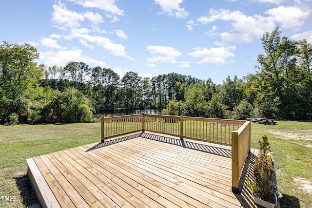 wooden terrace featuring a water view and a yard