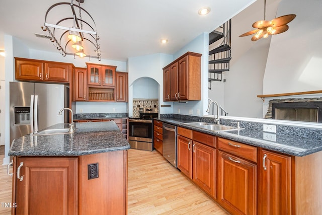 3313 Overhead Ct, Willow Springs, NC 27592 - kitchen featuring stainless steel appliances, light wood-type flooring, arched walkways, a ceiling fan, and brown cabinets