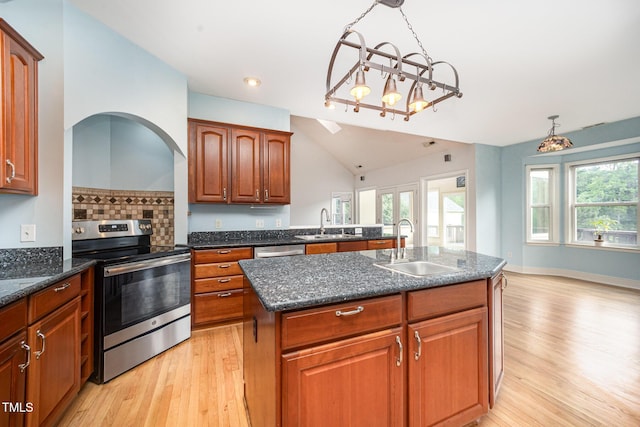 3313 Overhead Ct, Willow Springs, NC 27592 - kitchen featuring appliances with stainless steel finishes, light wood-style floors, a kitchen island with sink, lofted ceiling, and dark stone countertops