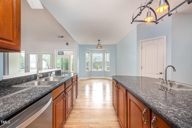 3313 Overhead Ct, Willow Springs, NC 27592 - kitchen with stainless steel dishwasher, light wood finished floors, brown cabinetry, pendant lighting, and dark stone countertops