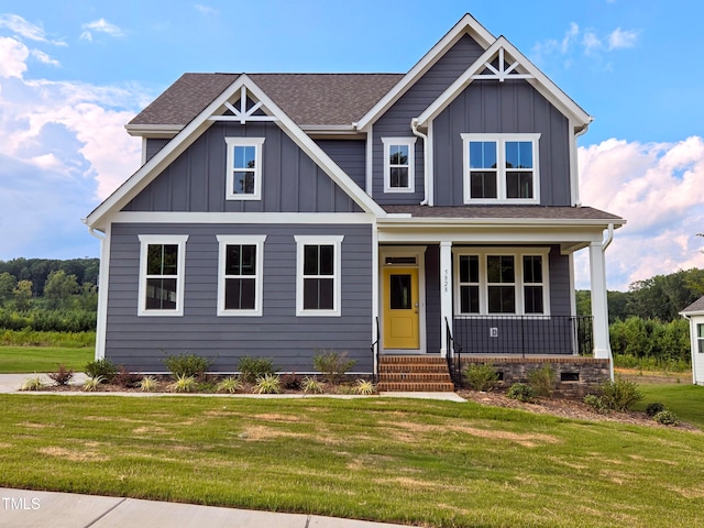 craftsman house with covered porch, board and batten siding, a front lawn, and roof with shingles