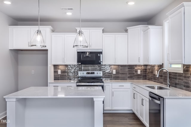 kitchen featuring visible vents, a sink, stainless steel appliances, white cabinets, and backsplash