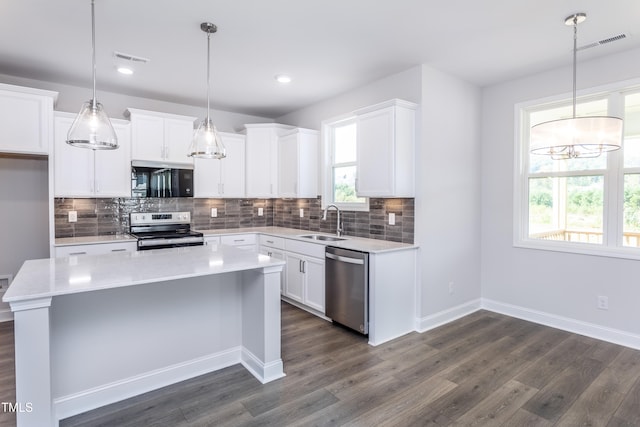 kitchen featuring visible vents, dark wood-style flooring, a sink, light countertops, and appliances with stainless steel finishes